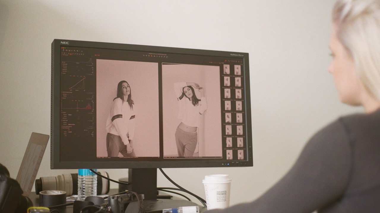 Naomi Grace Harris sits at a desk reviewing images on a computer monitor